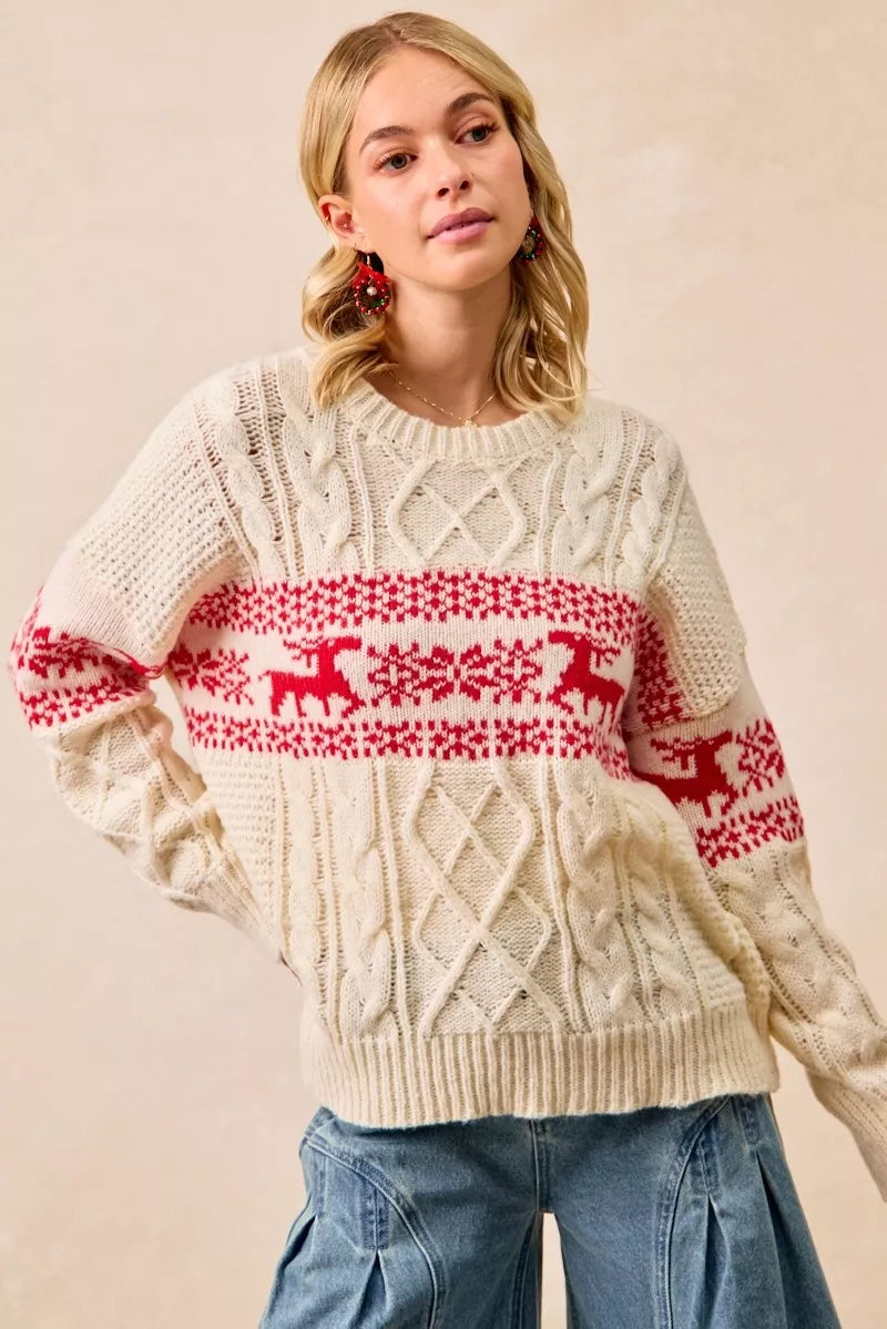 Christmas-themed cable knit sweater with festive red and white holiday pattern on a female model.