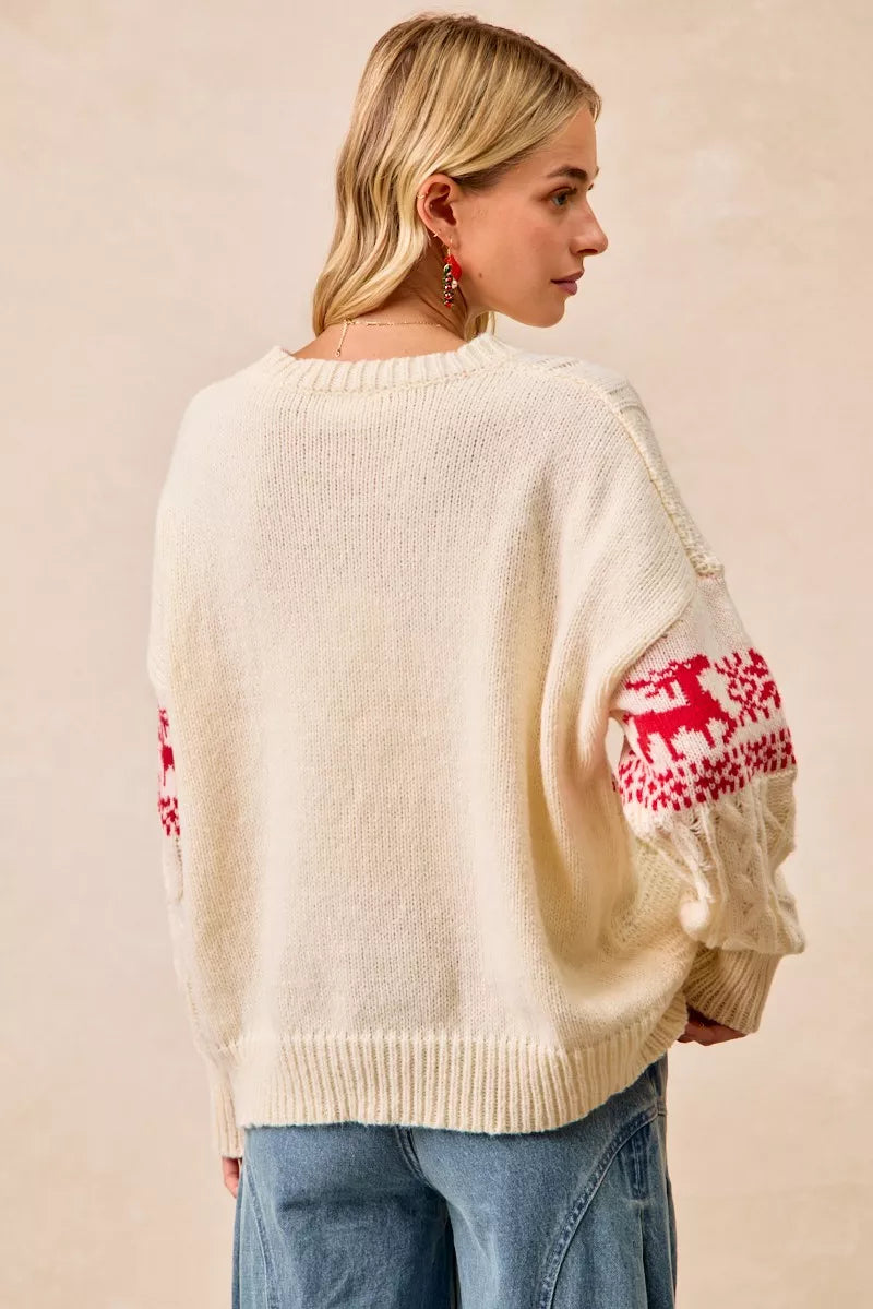 Christmas-themed cable knit sweater with festive red and white holiday pattern on a female model.