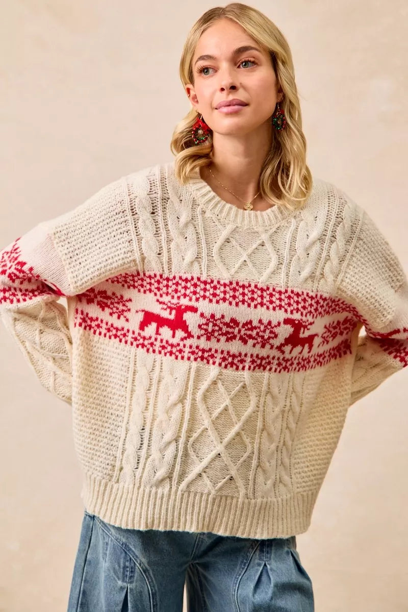 Christmas-themed cable knit sweater with festive red and white holiday pattern on a female model.